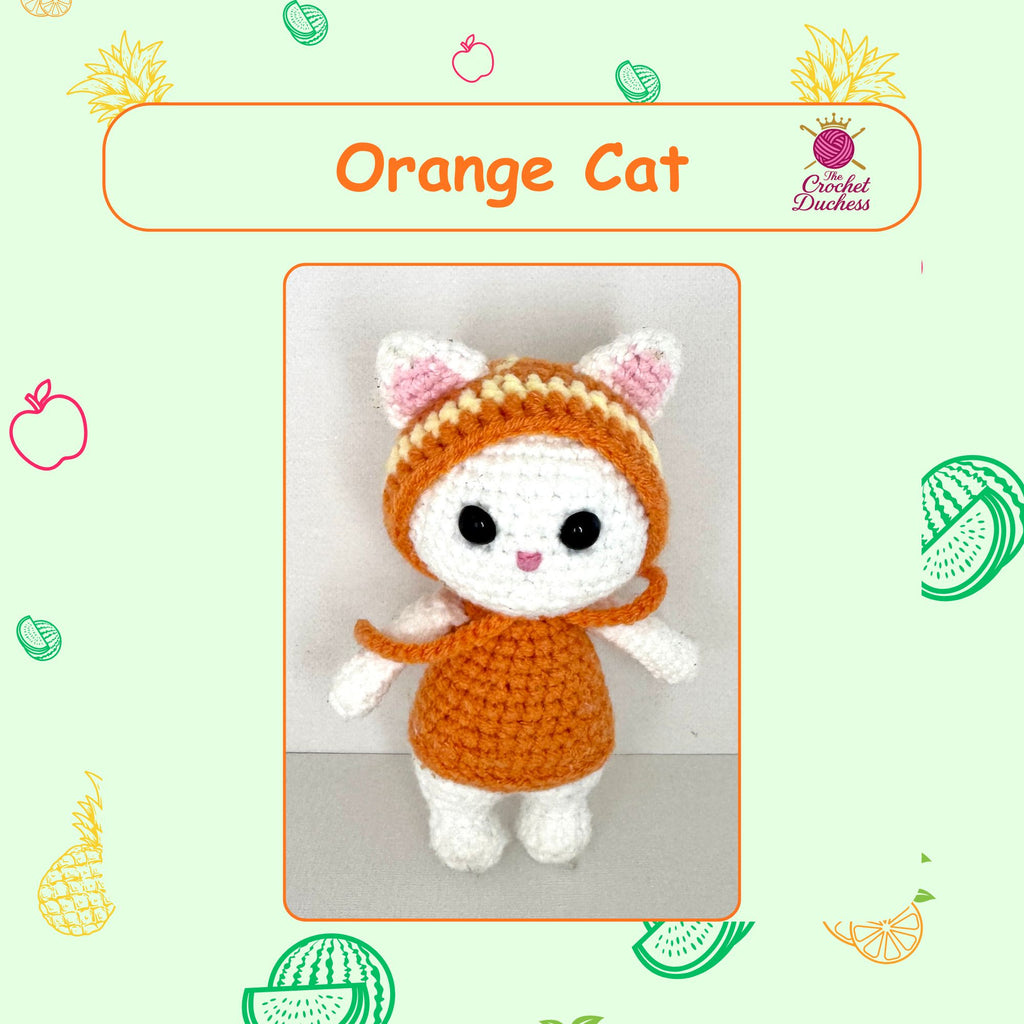 An orange and white crocheted amigurumi cat doll wearing a hooded outfit, centered on a light green background with fruit illustrations and the text 'Orange Cat' and 'The Crochet Duchess'.